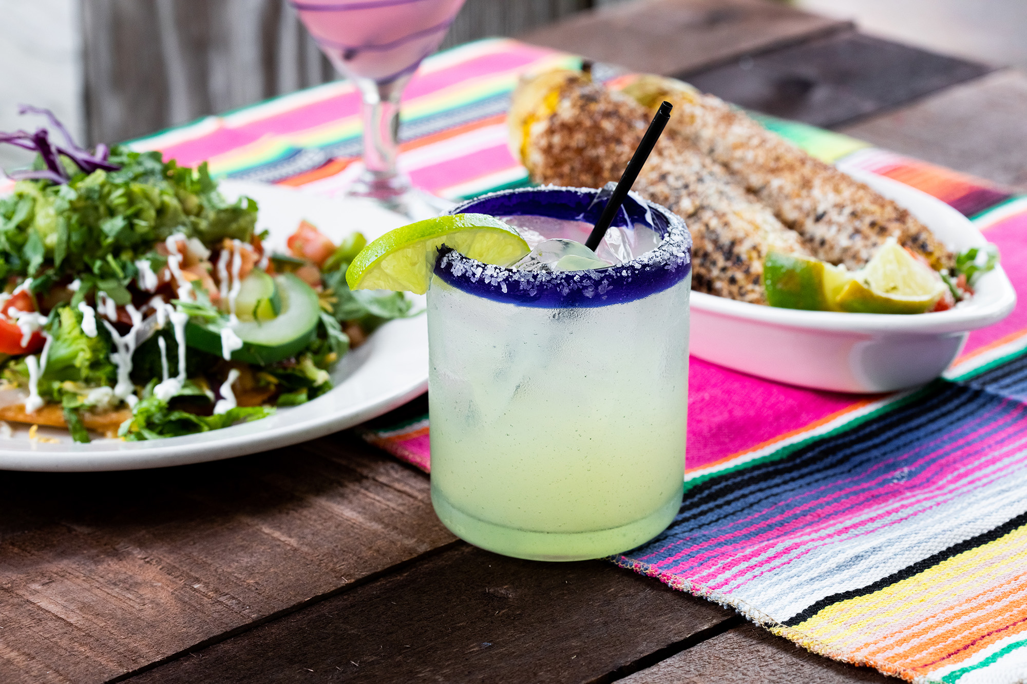House Margarita in front of Mexican Street Corn and a Salad | K38 Baja Grill